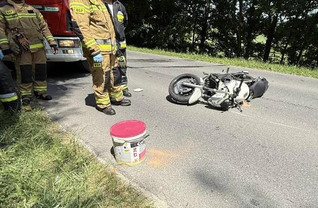 Rozbity biały motocykl leży na drodze