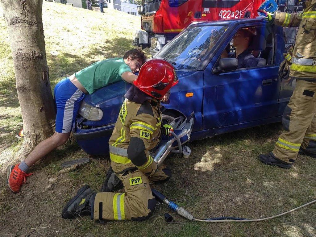 Strażak obok rozbitego auta osobowego