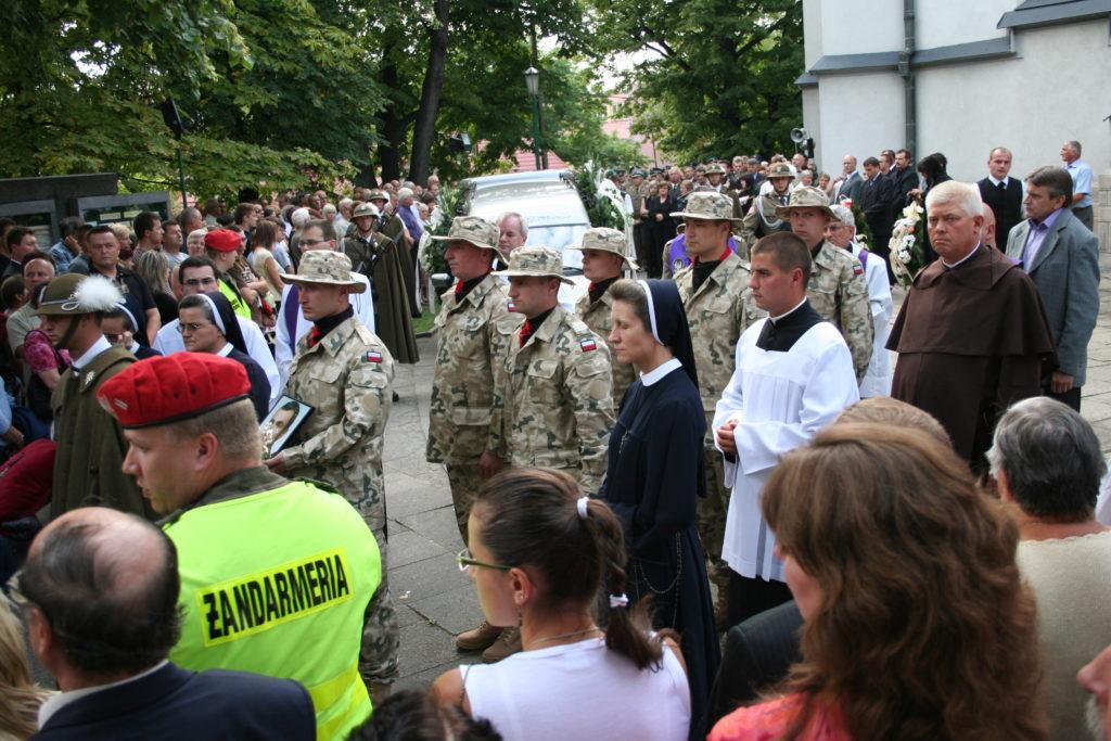 Tłum ludzi odprowadza na cmentarz poległego żołnierza