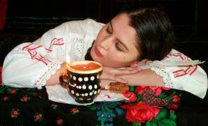 Kobieta, przed nią filiżanka kawy