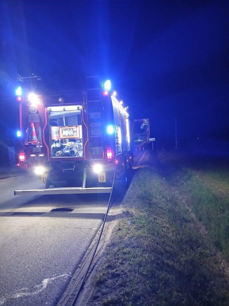 Wóz bojowy strazaków w nicy, z włączonymi niebieskimi światłami