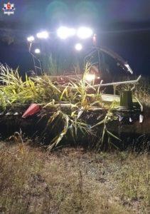 Kombajn kukurydziany w nocy z włączonymi światłami