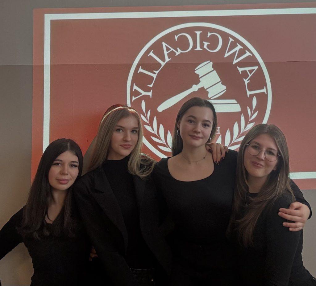 Cztery dziewczyny na tle logo szkoły