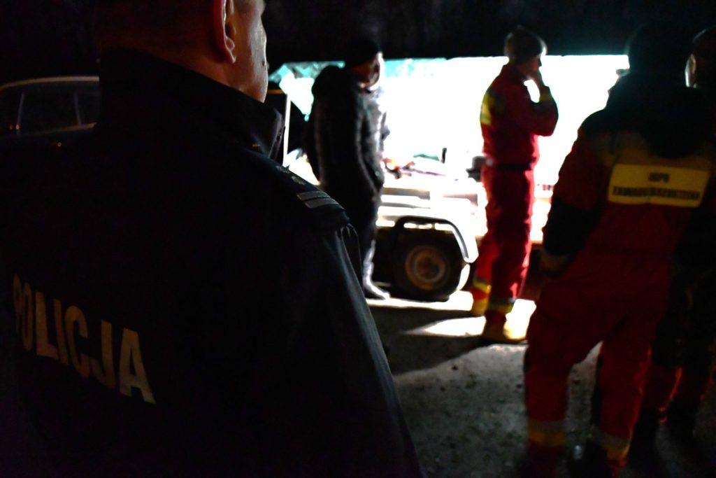 mroczne zdjecie, trzy osoby w tle rzeka