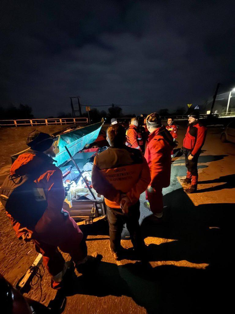 Noc, grupa ratowników w czerwonych strojach