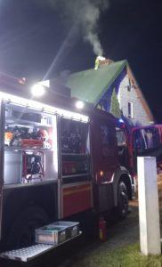 bojowy wóz strażacki, noc, dom z zielonym dachem, dym unoszący się z komina