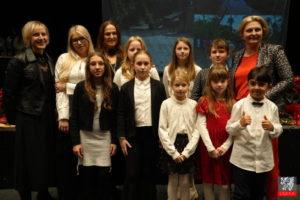 Grupa dzieci z dyplomami na scenie