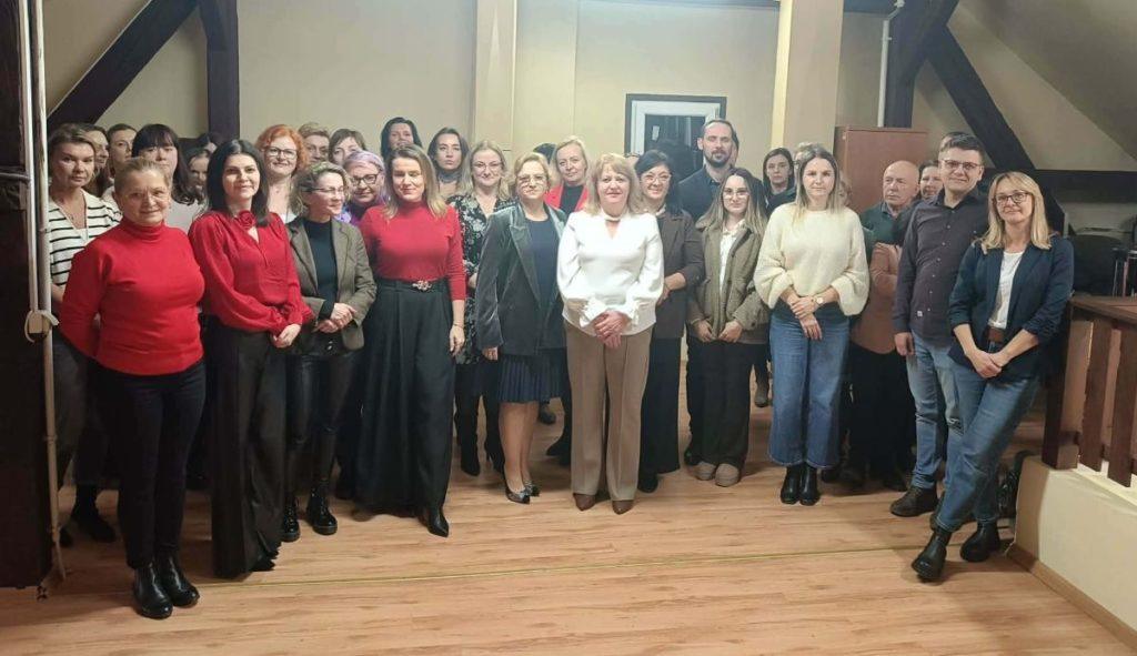 Grupa pracowników MOPS w Dębicy podczas uroczystego pożegnania pani Ewy Gil, zgromadzona we wspólnej, serdecznej atmosferze.