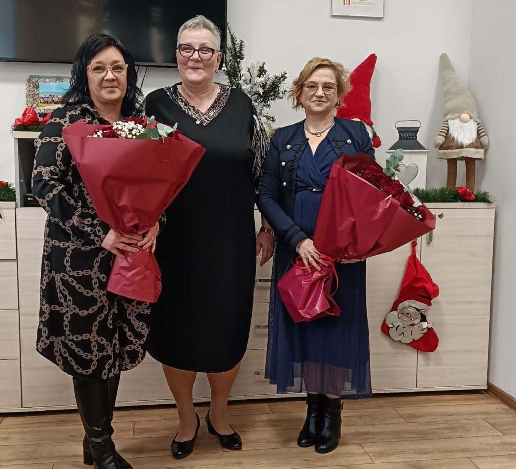 Trzy kobiety w odświętych strojach z bukietami kwiatów