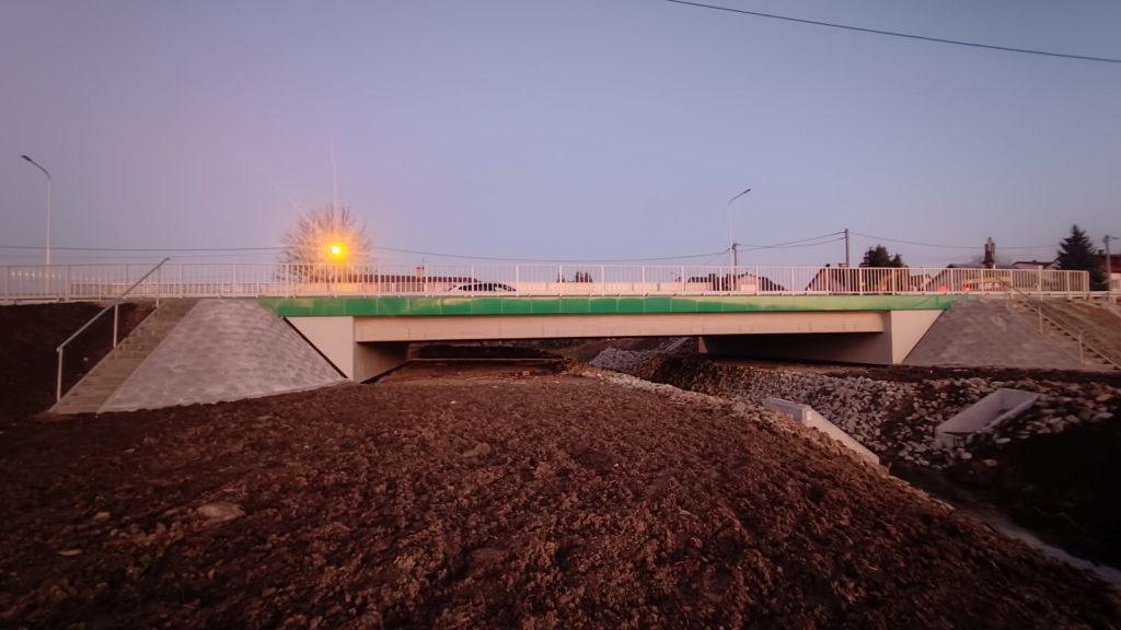 Most w kolorze szaro zielonym, nad rzeką, świecące lampy uliczne