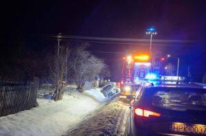 Zimowy wypadek drogowy w Starej Jastrząbce – samochód w rowie przy zaśnieżonej drodze, na miejscu straż pożarna, policja i służby ratunkowe