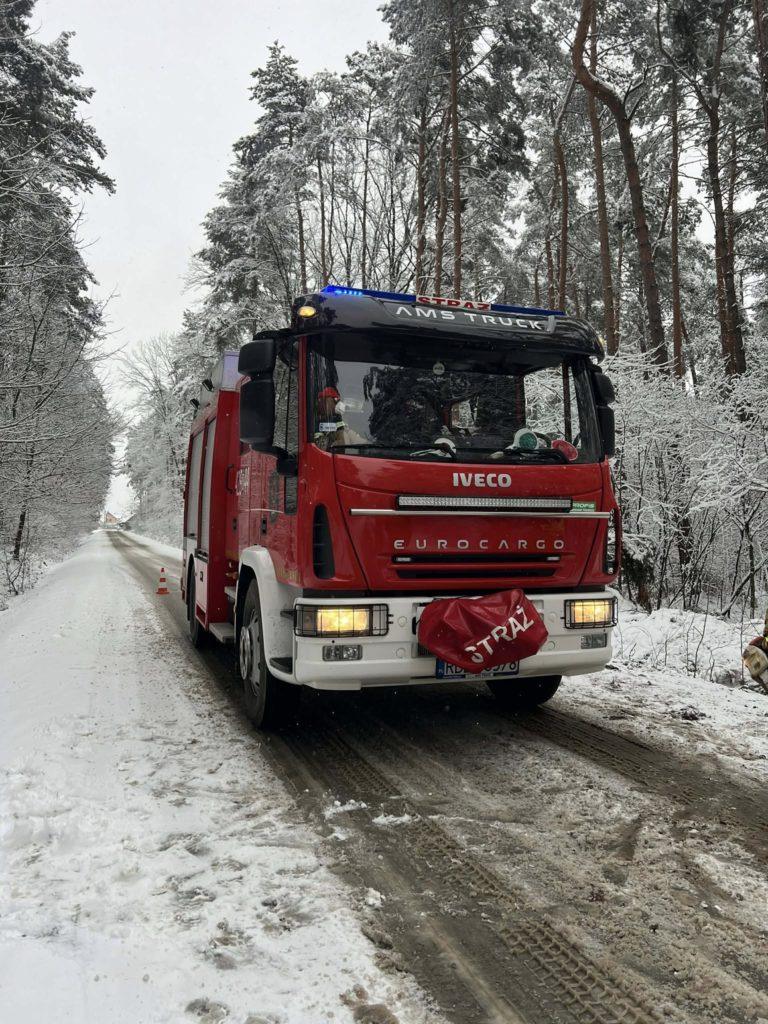 wóz strażacki na zaśnieżonej leśnej drodze