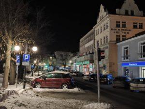 Rynek w Dębicy, zima, śnieg na ulicy, noc, zaparkowane samochody
