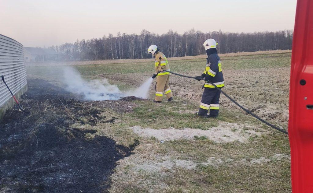 dwóch strażaków gasi pożar traw